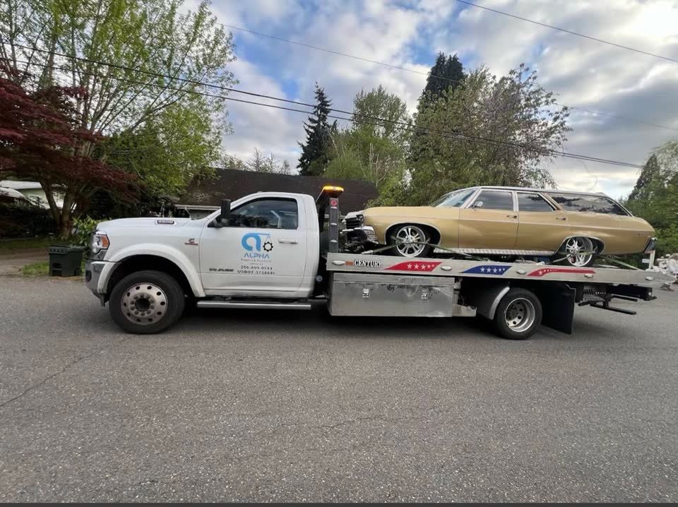 Alpha Towing Services flatbed truck on a Washington road